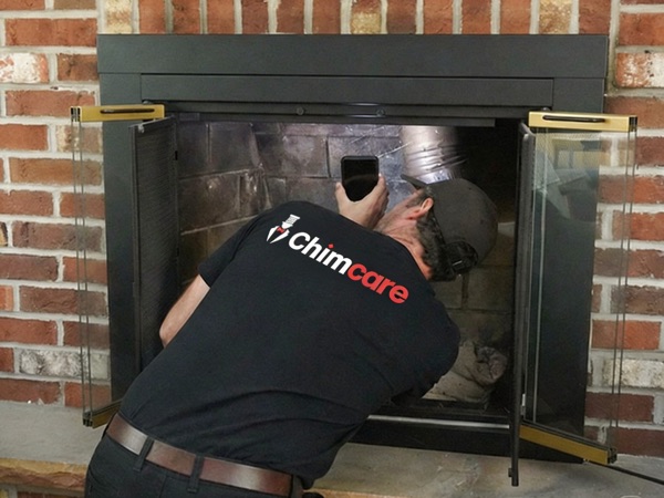 Technician inspecting a fireplace and documenting findings