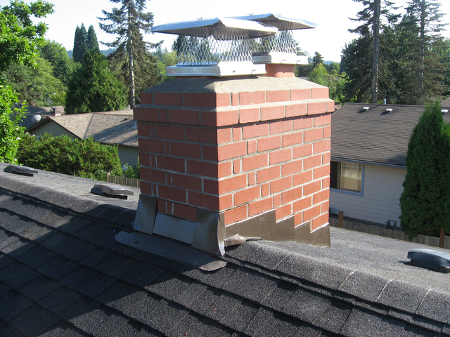 A red brick chimney with new step flashing where it meets the roof, topped with a stainless steel cap A red brick chimney with new step flashing where it meets the roof, topped with a stainless steel cap