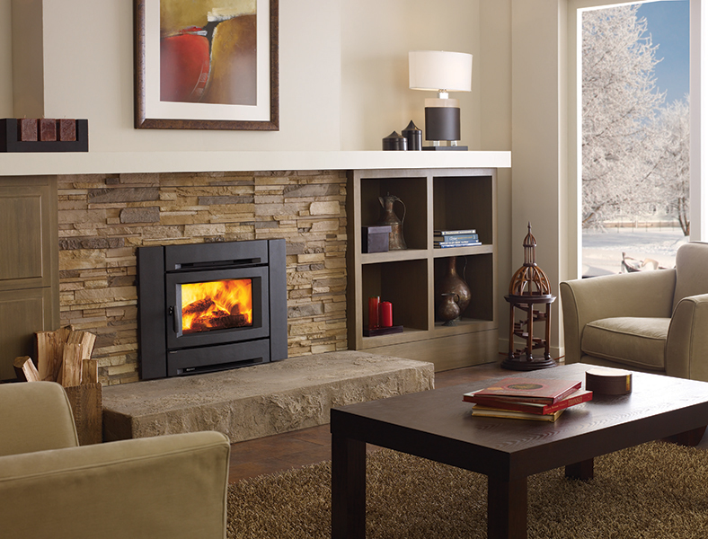 An Alterra wood insert burning in a stone fireplace in a living room