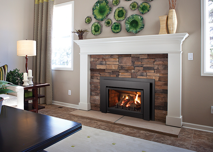 An Energy Medium gas insert in a stone surround below a white mantel