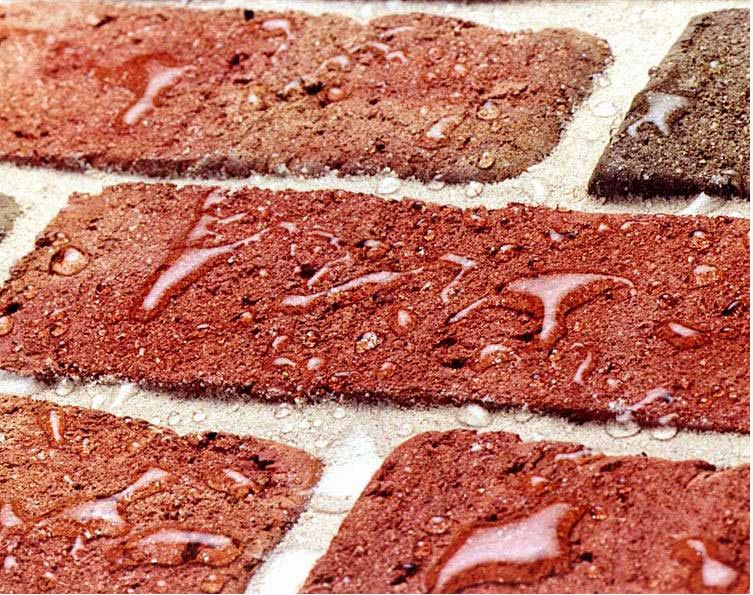 Water beading on red brick treated with a water repellent