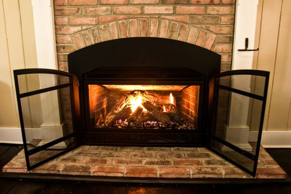 A serviced gas fireplace burning behind a screen A serviced gas fireplace burning behind a screen